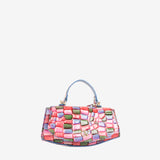 A structured handbag with a multicolor mosaic patchwork pattern in pink, red, green, and purple, featuring a light blue leather top handle and gold-tone hardware, set against a plain light gray background. #color_pink