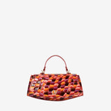 A structured handbag with a curved bottom and top handle, featuring a glossy mosaic pattern of orange, red, pink, and purple scales, set against a plain light gray background. #color_orange