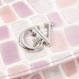 A close-up of a silver metal monogram charm featuring the letters 'C' and 'V' with a small star detail, resting on a pastel pink and lavender patterned surface. #color_lilac
